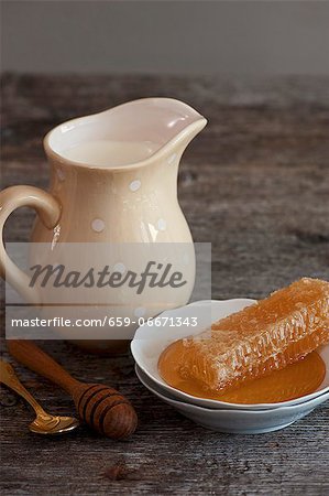Milk in a porcelain jug and a honeycomb