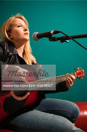 Woman Playing Acoustic Guitar and Singing