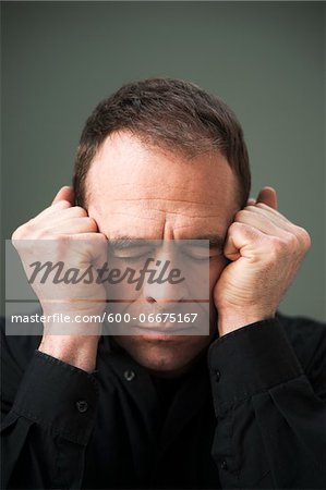 Head and Shoulders Portrait of Mature Man Eyes Closed and Fists by Head