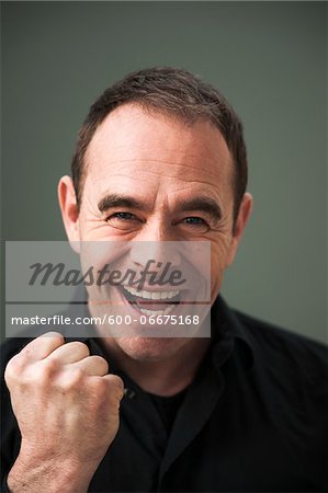 Head and Shoulders Portrait of Mature Man Smiling and Pumping Fist