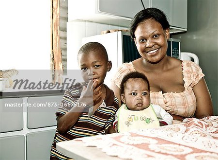 Adult African woman sitting in her bedroom, smiling at camera