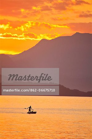 Brazil, Rio de Janeiro State, Angra dos Reis, Ilha Grande, a fisherman silhouetted against the sunset over the Costa Verde, Green Coast,