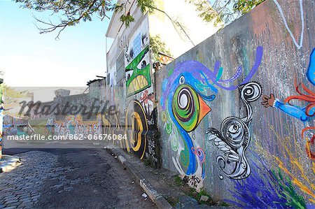 South America, Brazil, Sao Paulo, Vila Madalena, the Beco do Batman   an alley covered in Brazilian graffiti under the yellow neon glow of the Sao Paulo sky