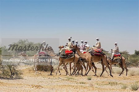 Chad, Kanem, Bahr el Ghazal, Sahel. A group of Kreda men ride their camels near the Bahr el Ghazal seasonal river.