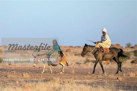 Chad, Biltine, Oum-Chelouba, Sahel. A man and his wife return home after watering livestock at a well near Oum-Chelouba.