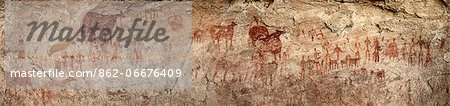 Chad, Gaora Hallagana, Ennedi, Sahara. An ancient rock painting of human figures and their livestock during the Pastoral Period.