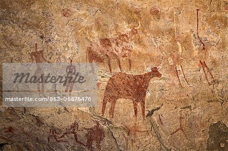 Chad, Deli, Ennedi, Sahara. A bichrome rock art panel on sandstone of human figures, cattle and two ostriches.