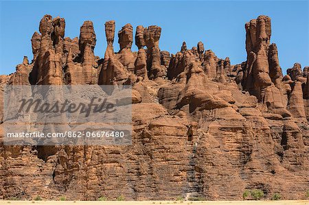 Chad, Kachabi, Ennedi, Sahara. A striking array of weathered red sandstone columns and pinnacles on a cliff near Kachabi.