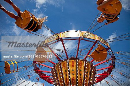 UK, Wiltshire. Children enjoy the chair-O-plane ride at a traditional steamfair.