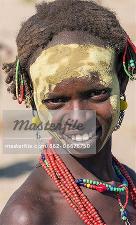 A Dassanech woman with yellow ochre on her face in preparation for a Dimi ceremony, Ethiopia