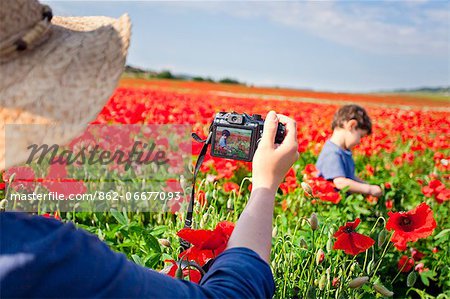 Italy, Tuscany, Siena district, Orcia Valley. Family in a poppies field
