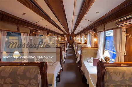 South America, Peru, Cusco, Sacred Valley. The dining car with tables set for dinner on the Orient Express Hiram Bingham train which runs between Cusco, Poroy, and Machu Picchu via Ollantaytambo