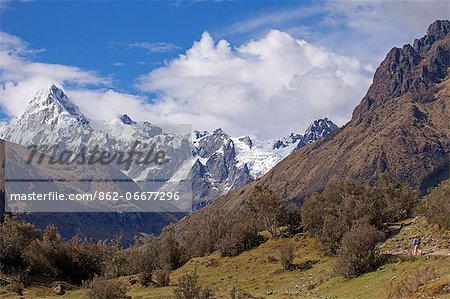 South America, Peru, Ancash, Cordillera Blanca. hiker with backpack walking on the Santa Cruz trek in Huascaran National Park, with the Quebrada Santacruz and the Taulliraju snowfields in the background