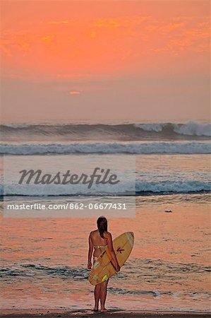 South America, Peru, La Libertad, Trujillo, Huanchaco, a surfer on the beach in front of Pacific rollers and a golden sunse