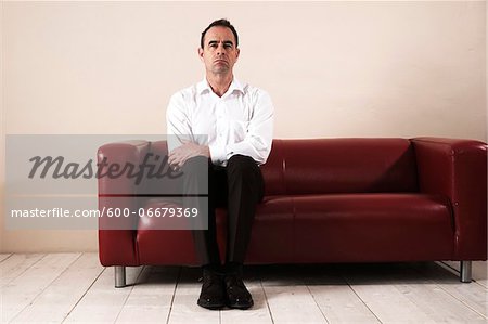 Mature Man Sitting on Sofa, Waiting