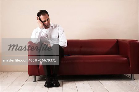 Mature Man Sitting on Sofa and Waiting