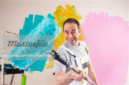 Portrait of Mature Man with Paint Roller Renovating his Home