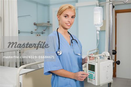 Nurse next to a monitor looking at camera