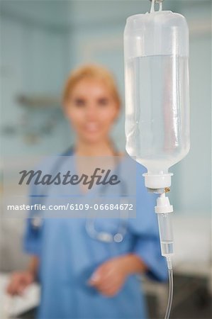 Focus on an intravenous drip next to a nurse