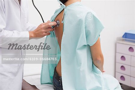 Close up of doctor auscultating the patient back with a stethoscope
