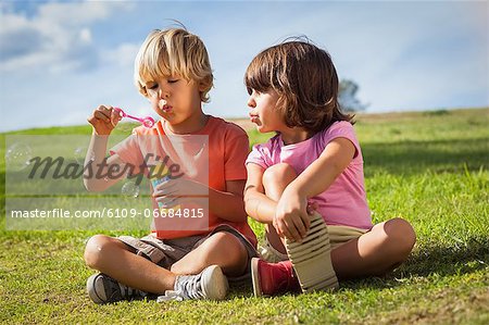 Brother and sister blowing bubbles