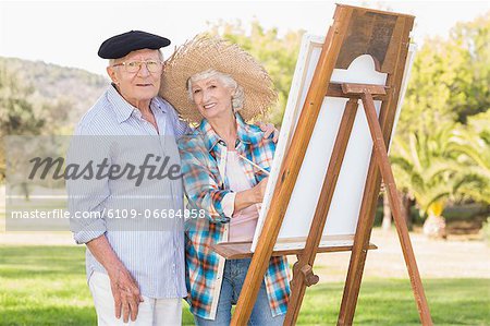 Portrait of older couple painting in the park