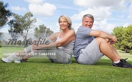 Portrait of older couple in sportswear back to back