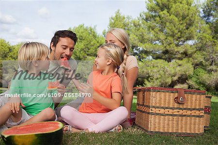 Happy family having a picnic and eating watermelon