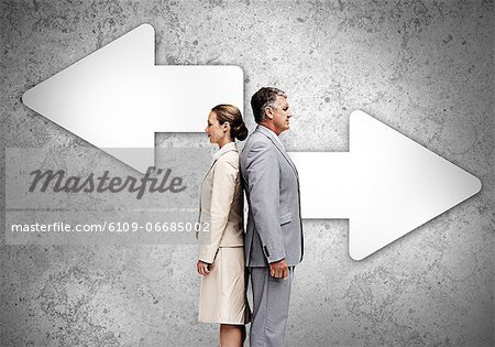 Business partners standing back to back on wall with arrows Business partners standing back to back on wall with arrows