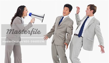 Businesswoman with megaphone shouting at colleagues against a white background