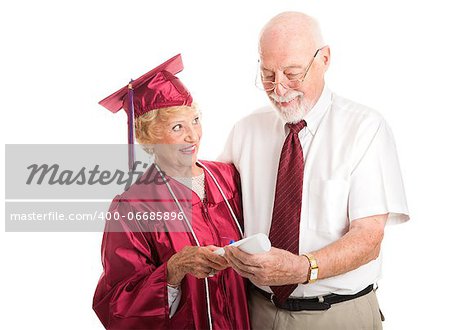 Senior woman graduating from college, proudly shows her diploma to her husband.  Isolated on white.