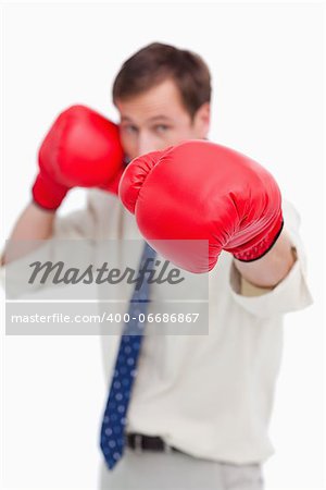 Attacking businessman with boxing gloves against a white background