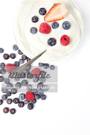 Bowl of cream with fruits  against a white background