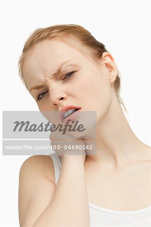 Young woman massaging her painful back against white background