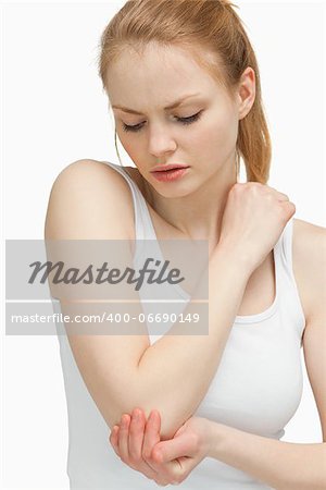 Woman touching her elbow against white background