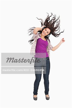 Brunette listening to music with her hair in the hair against white background