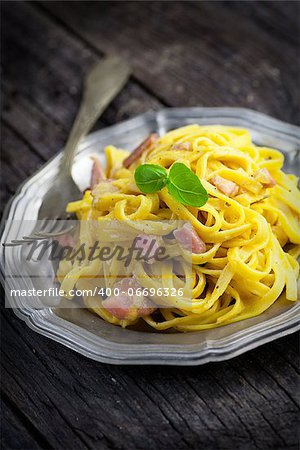 Italian cooking. Pasta spaghetti carbonara with ham, eggs and basil
