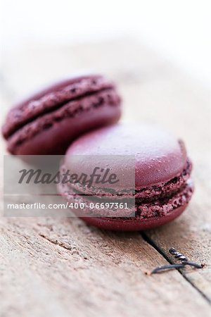 Closeup of two chocolate macaroons on wooden table