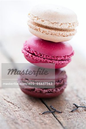 Closeup of stack of three different flavoured macaroons on wooden table