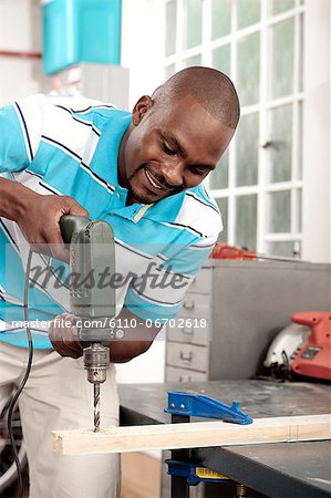 African man using drill in a workshop