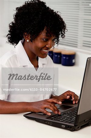 An African teenage girl working on a laptop