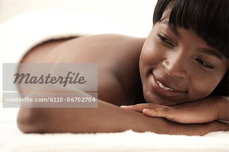 Young black woman lying in a salon, wearing a towel
