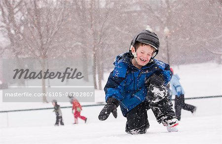 Boy getting up from a fall on skating rink