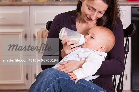 Mother feeding her son from bottle