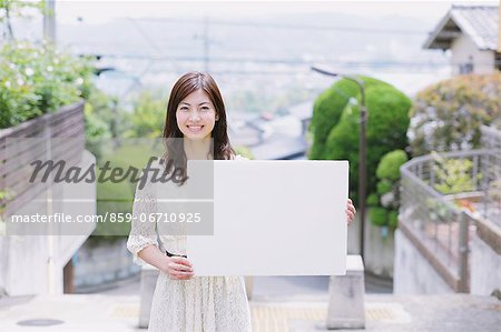 Japanese woman with a whiteboard smiling at camera