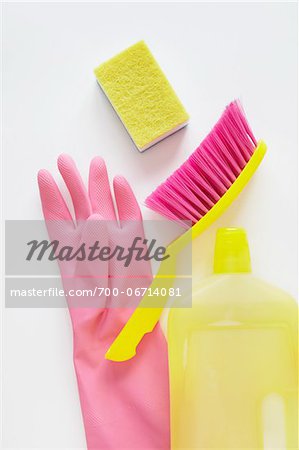 still life of cleaning products including sponge, bottle of cleaner, rubber glove, and hand broom