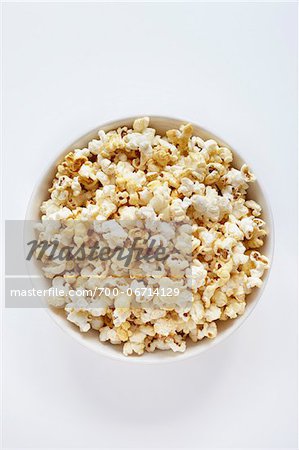 Popped popcorn in bowl on white background