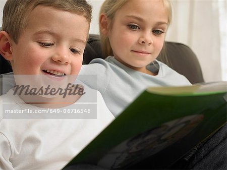 Children reading together on sofa