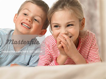 Children laughing together on bed