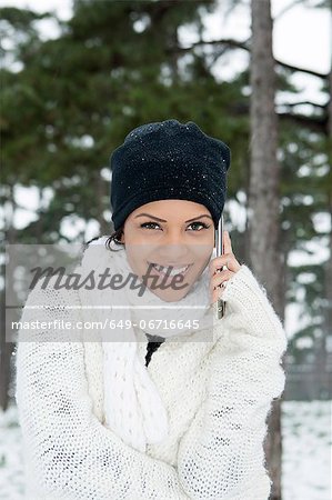 Woman on cell phone in snowy forest